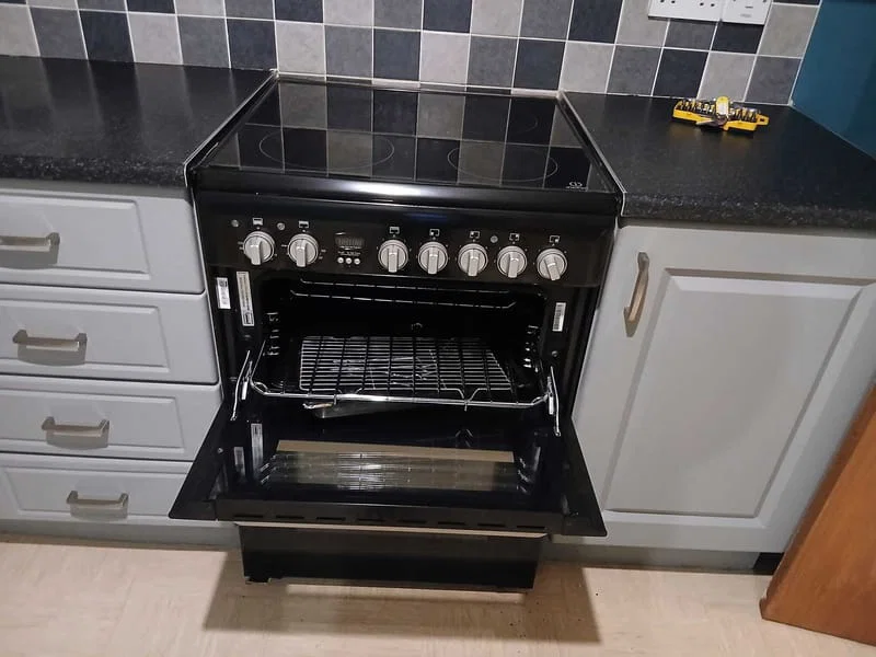 Open oven in a white fitted kitchen